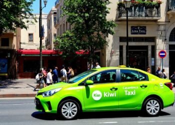 Vibrant lime green taxi parked on city street with pedestrians