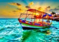 Colorful fishing boat floating on turquoise waters at golden sunset
