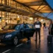 Professional taxi driver with passengers at airport terminal entrance