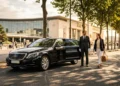 Couple sortant d'une berline noire devant bâtiment moderne
