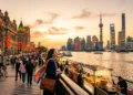 Femme admirant le skyline de Shanghai au coucher du soleil