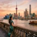 Shanghai travel guide : must-visit attractions & tips Woman in green dress overlooking Shanghai's illuminated skyline at sunset